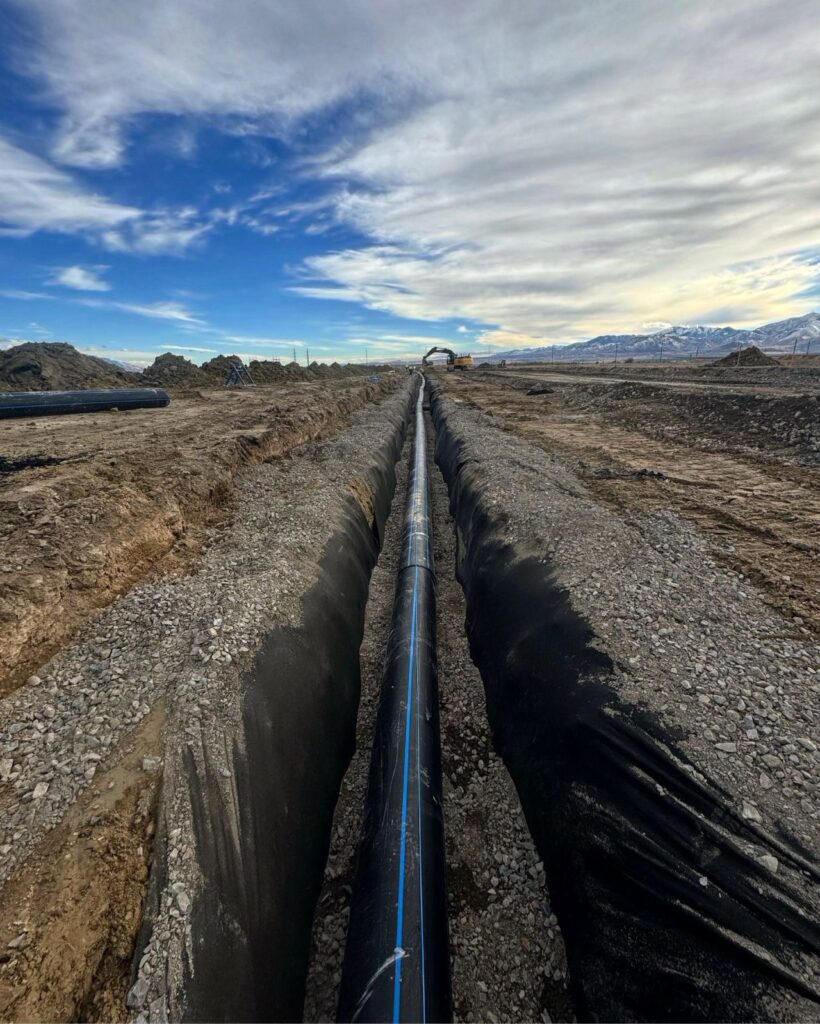 Wet utility installation in the ground, ready for backfill in Utah.